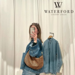 a woman posing with clothes hanging on hook behind her